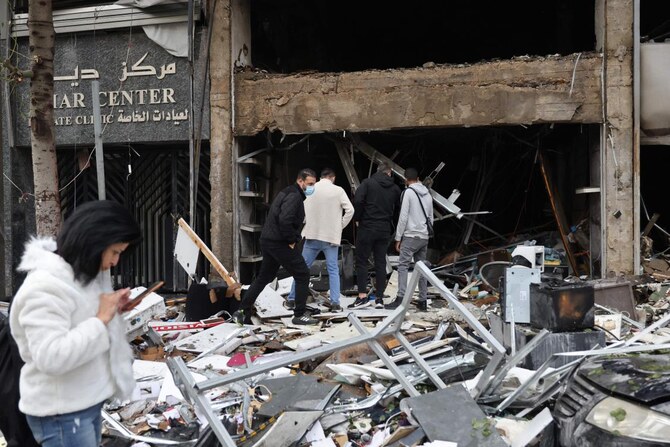 People inspect the damage to a building, targeted in an Israeli airstrike the previous day, in Beirut’s Mar Elias Street on November 18, 2024, amid the ongoing war between Israel and Hezbollah. (Photo by ANWAR AMRO / AFP)