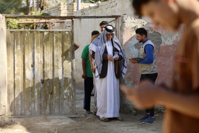 An Iraqi census researcher collects information from a man in the town of Al-Taliah, south of the city of Hilla, on Nov. 20, 2024. (AFP)