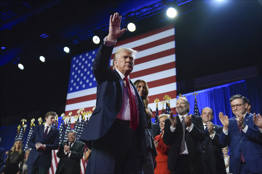 Trump waves as he walks with former first lady Melania Trump at an election night watch party at the Palm Beach Convention Center, Wednesday, Nov. 6. (AP)