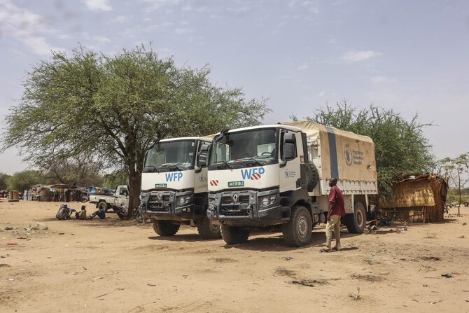 Trucks from the World Food Program (WFP are parked near temporary shelters for Sudanese refugees from the Tandelti area who crossed into Chad, in Koufroun, near Echbara, on April 30, 2023. (AFP)