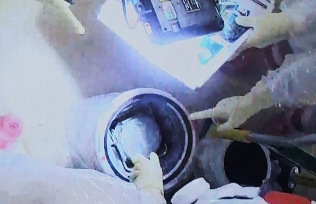 This handout photo taken and released on November 7, 2024 from Tokyo Electric Power Company (TEPCO) shows employees loading a transportation box containing fuel debris from Unit 2 into a DPTE (double porte pour transfert etanche) container, at TEPCO's Fukushima Daiichi nuclear power plant in Okuma, Fukushima prefecture. (AFP)