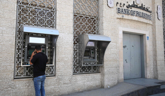 A man withdraws cash from an ATM machine at Bank of Palestine in Khan Younis in the southern Gaza Strip on May 15, 2018. (AFP)