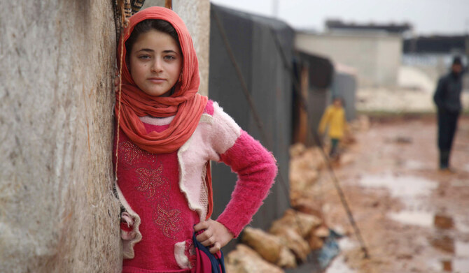 A displaced Syrian girl stands in the entrance of a tent at the Qah camp for the displaced along the Turkish border in the northwestern province of Idlib, on January 31, 2019. (AFP)