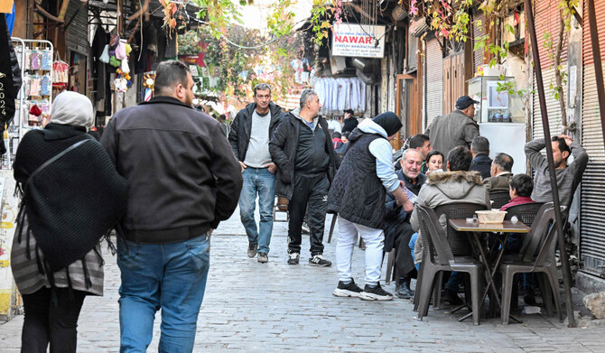 People sit at a coffee shop in the old city of Syria's capital Damascus on December 6, 2024. (AFP)