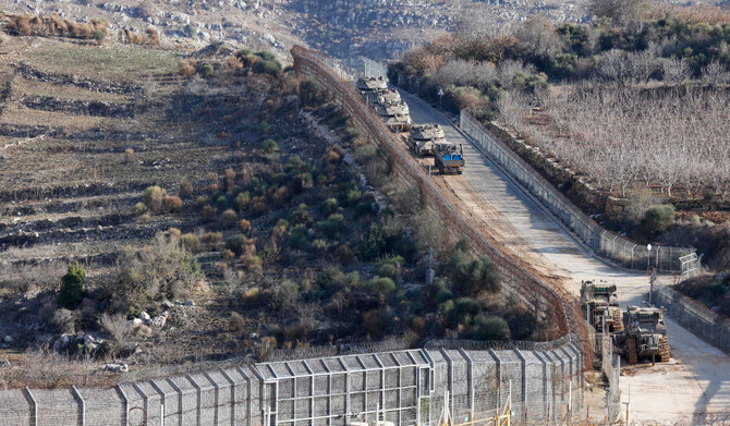 Israeli soldiers joke next to an armored vehicle parked near the so-called Alpha Line that separates the Israeli-annexed Golan Heights from Syria, in the town of Majdal Shams, Monday, Dec. 9, 2024. (AP)