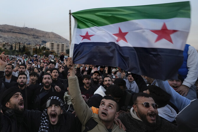 Syrian citizens wave the revolutionary flag and shout slogans, as they celebrate during the second day of the take over of the city by the insurgents in Damascus, Syria, Monday, Dec. 9, 2024. (AP)