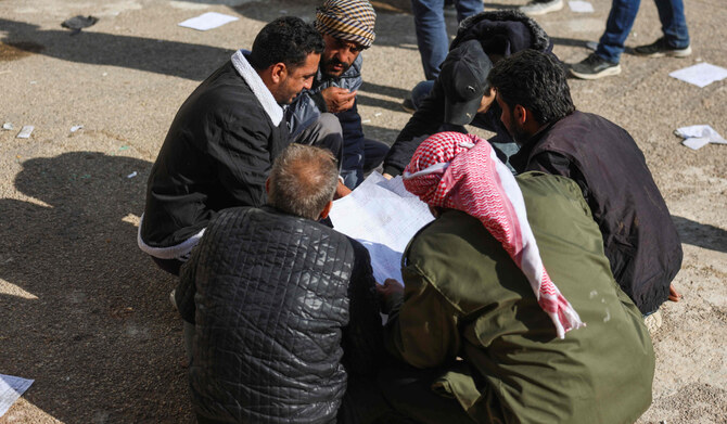 People read registers found at the Saydnaya prison as they look for information on their loved ones while Syrian rescuers search for potential hidden basements at the facility in Damascus on December 9, 2024. (AFP)