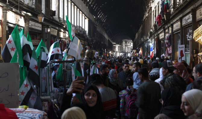 People walk past shops in the Al-Hamidiya market in the old city of Syria's capital Damascus on December 12, 2024. (AFP/File)