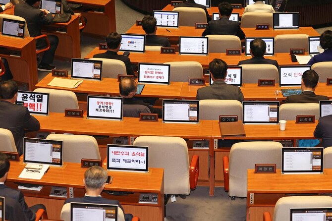Members of the Democratic Party of Korea display messages calling for the impeachment of South Korea President Yoon Suk Yeol during a National Assembly plenary session in Seoul on Dec. 13, 2024. (Yonhap/AFP)