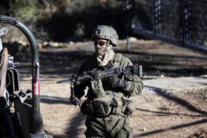 An Israeli soldier stands by the ceasefire line between the Israeli-occupied Golan Heights and Syria, as seen from Majdal Shams in the Golan Heights, December 15, 2024. (Reuters)