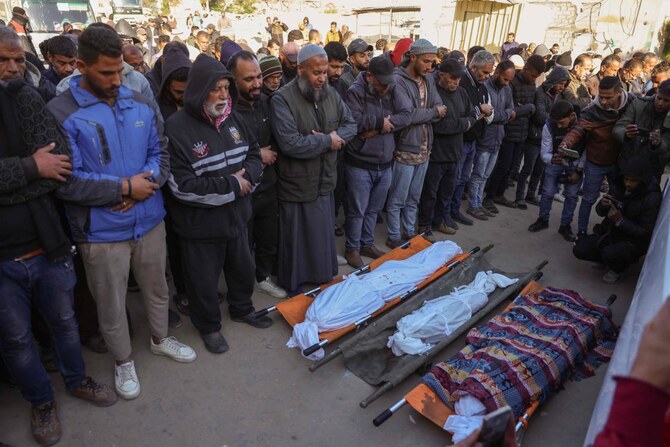People pray by victims of Israeli strikes on the Ahmad Abdulaziz UNRWA-run school currently housing displaced families in Khan Younis on Dec. 16, 2024. (AFP)