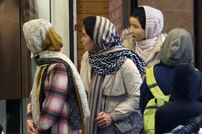 Iranian women, wearing the mandatory hijab, window shop in the capital Tehran on December 12, 2024. (AFP)