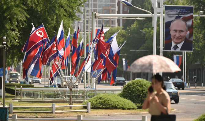 A portrait of Russian President Vladimir Putin is seen near national flags of North Korea and Russia in Pyongyang on June 20, 2024. (AFP/File)