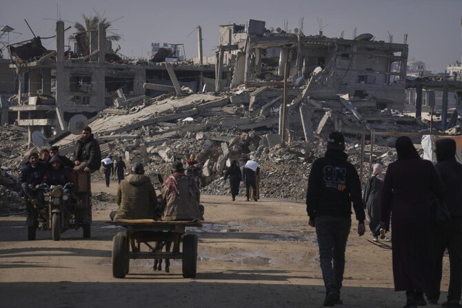 Palestinians carry UN-donated flour in Khan Younis, central Gaza Strip. (File/AP)