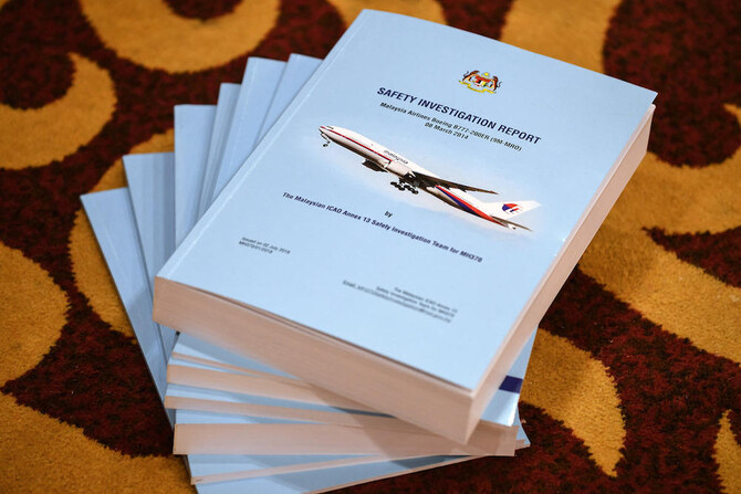 Above, copies of the MH370 safety investigations report are seen on the floor during a media briefing in Putrajaya, outside Kuala Lumpur, on July 30, 2018. (AFP file photo)