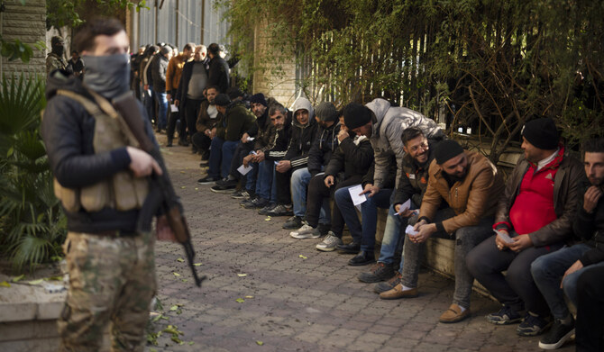 Members of Bashar Assad's army, or a pro-government militia, line up to register with Syrian rebels as part of an