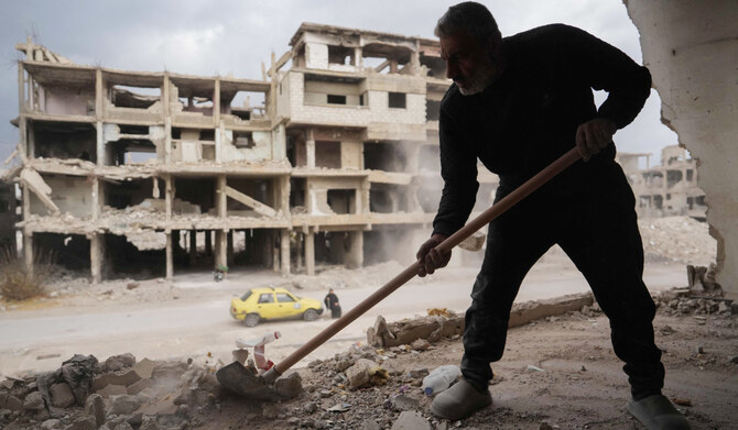 A man clears rubble and debris from a damaged house at the Yarmuk camp for Palestinian refugees south of Damascus on December 22, 2024. (AFP)