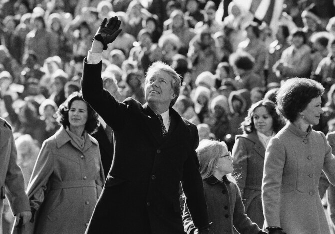President Jimmy Carter waves to the crowd while walking with his wife Rosalynn and their daughter Amy along Pennsylvania Avenue. (AP/File Photo)