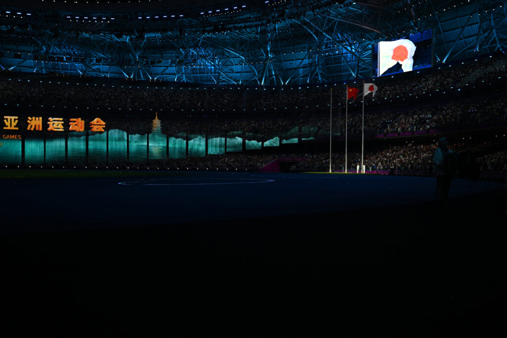 The flag of Japan, host for the upcoming Aichi-Nagoya 2026 Asian Games, flies alongside the Chinese flag during the closing ceremony of the 2022 Asian Games at the Hangzhou Olympic Sports Centre Stadium in Hangzhou in China's eastern Zhejiang province on October 8, 2023. (AFP)