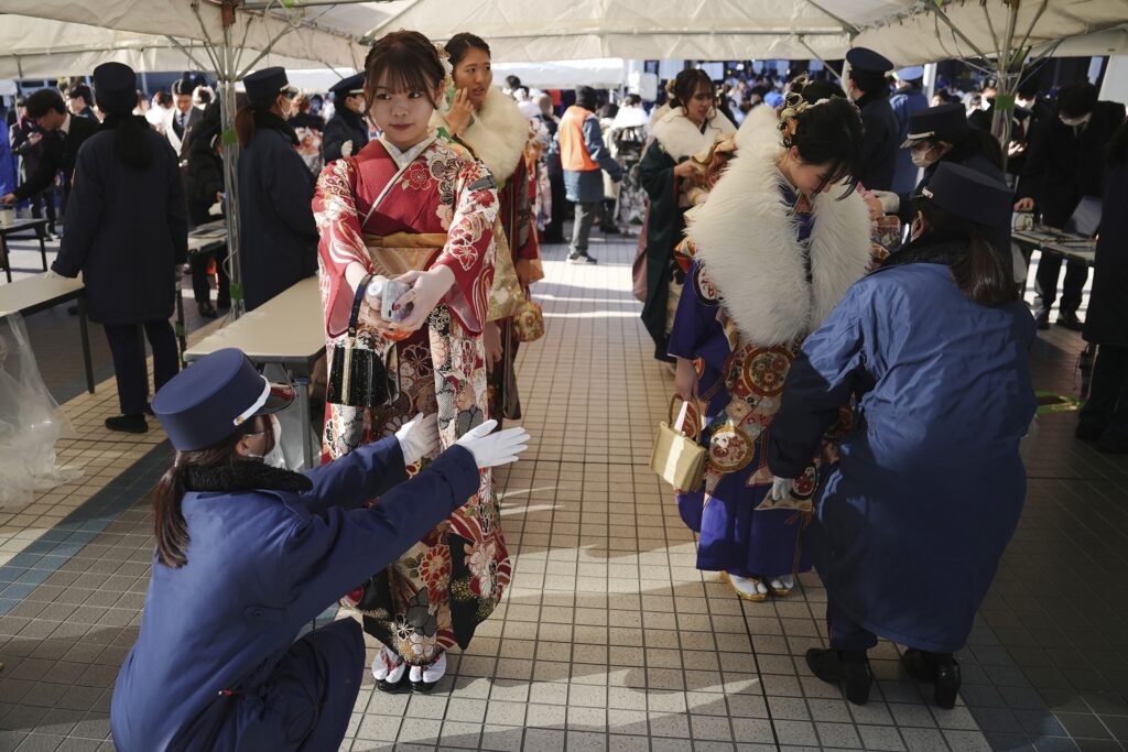 Kimono-clad women are checked at a security checkpoint as they arrive to celebrate the Coming-of-Age Day, a centuries-old tradition and national holiday celebrating the milestone from child to adult, in Yokohama near Tokyo, Monday, Jan. 13, 2025. (AP Photo/Eugene Hoshiko)