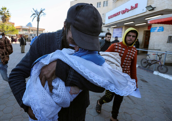 Yahya Al-Batran clutched the tiny clothes of his dead newborn son Jumaa, just days after the baby died from the cold in their tent in war-torn Gaza. (REUTERS)