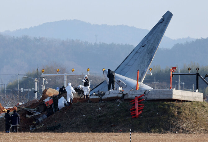 Officials take part in an investigation at the site where a Jeju Air Boeing 737-800 aircraft crashed and burst into flames at Muan International Airport in Muan, South Korea, on January 1, 2025. (YONHAP/AFP)