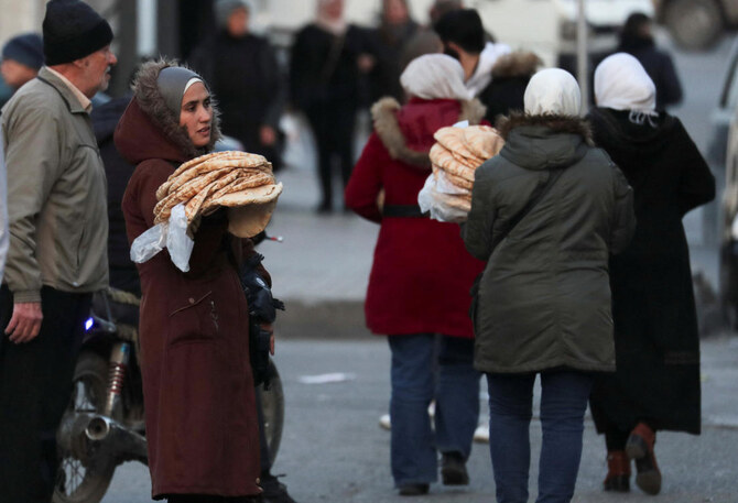 Women carry bread as they cross a street after the ousting of Syria's Bashar Al-Assad, in Damascus, Syria, January 6, 2025. (Reuters)