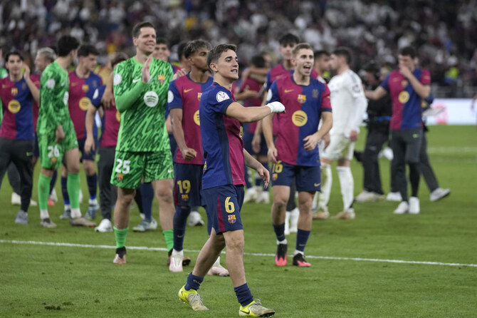 Barcelona players celebrate at the end of the Spain Super Cup final between Real Madrid and Barcelona at King Abdullah Stadium in Jeddah, Saudi Arabia, Monday, Jan. 13, 2025. (AP)