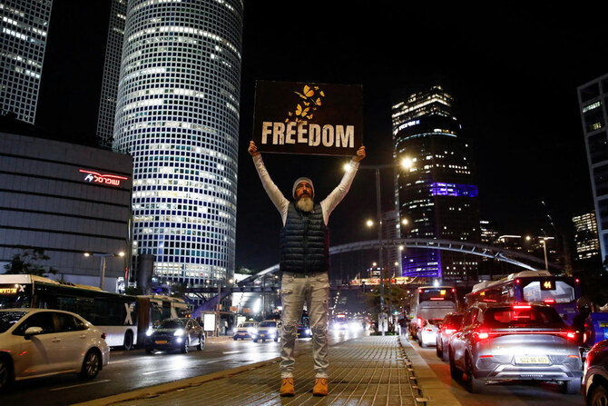 A man holds a placard on a road as supporters and family members of hostages kidnapped during the deadly October 7, 2023, attack on Israel by Hamas, protest ahead of a ceasefire between Israel and Hamas, in Tel Aviv, Israel, January 16, 2025. (Reuters)