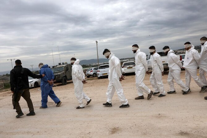 An Israeli soldier supervises the transfer of Palestinian men arrested during a military raid on Jenin. (AFP)