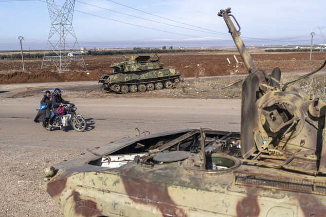 A family drives past tanks that belonged to the Assad government, in Nawa, near Daraa, Syria, o. Jan. 4, 2025. (AP)