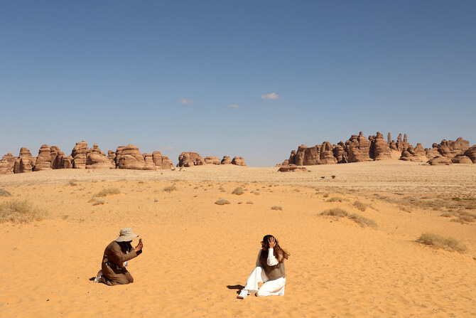 Above, a tourist being photographed in front of rose-colored sandstone hills in Madain Sale near Saudi Arabia’s northwestern town of AlUla on Jan. 26, 2024. (Royal Commission for AlUla/AFP)