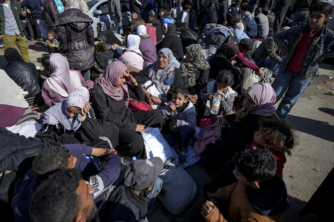 Displaced Palestinians gather near a roadblock, as they wait to return to their homes in the northern part of the Gaza Strip, Sunday, Jan. 26, 2025. (AP)