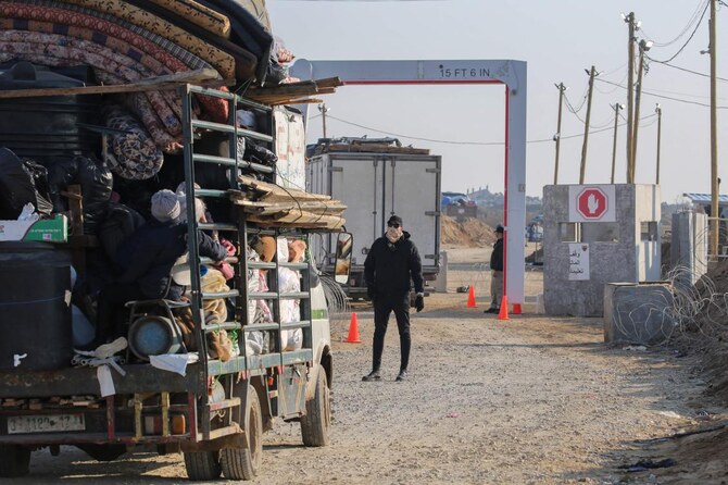 Displaced Palestinians cross a checkpoint manned by Hamas security at the Nezarim corridor as people make their way from the south to the northern parts of the Gaza Strip, on Salah al-Din road, in Mughraqa in central Gaza, on January 29, 2025. (AFP)