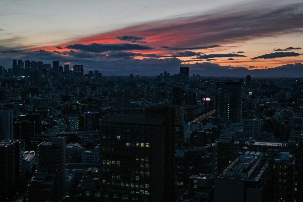 The skyline of Shinjuku (L) is pictured in front of a sunset, as the sky cleared following a couple of rainy days in the Japanese capital of Tokyo on October 30, 2024. (AFP)