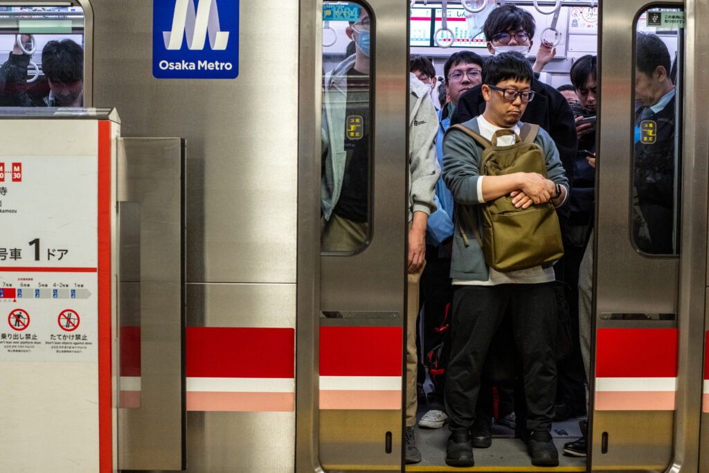 People commute on a subway train in Osaka on November 22, 2024. (AFP)