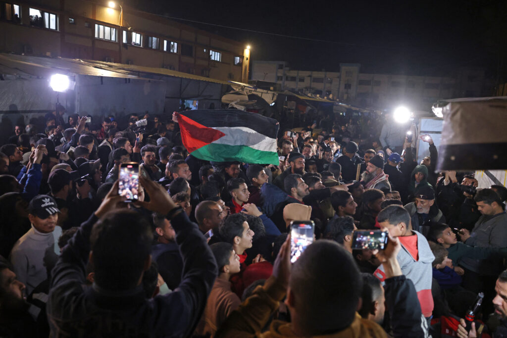 People watch a television along a street in Khan Yunis in the southern Gaza Strip on January 15, 2025, amid the ongoing war in the Palestinian territory between Israel and Hamas. (AFP)