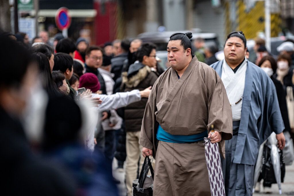 People gather at the entrance of Ryogoku Kokugikan for the arrival of sumo wrestlers during the Grand Sumo Tournament in Tokyo on January 19. (AFP)