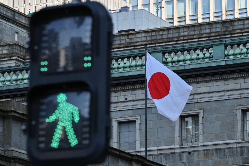 The Japanese flag flies over the Bank of Japan (BoJ) headquarters complex in central Tokyo on January 23, 2025. Japan's economic growth slowed sharply in 2024, cabinet office data showed on February 17, 2025, although the rate for the fourth quarter beat market expectations thanks to strong exports. (AFP)