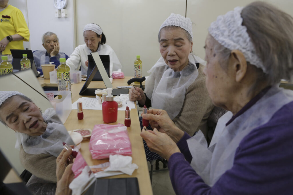 Participants try on makeup at a special class at a Tokyo housing complex that teaches people to stay healthy and beautiful, on Feb. 14, 2025. (AP Photo/Yuri Kageyama)