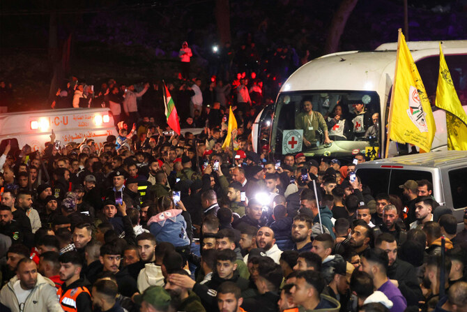 A Red Cross convoy transporting Palestinian prisoners released by Israel is welcomed by a crowd as it arrives in Ramallah in the occupied West Bank on January 30, 2025.(AFP)