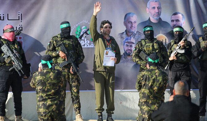 Palestinian militant group Hamas fighters escort Israeli-French hostage Ofer Kalderon on a stage before handing him over to a Red Cross team in Khan Yunis on February 1, 2025, as part of fourth hostage-prisoner exchange. (AFP)