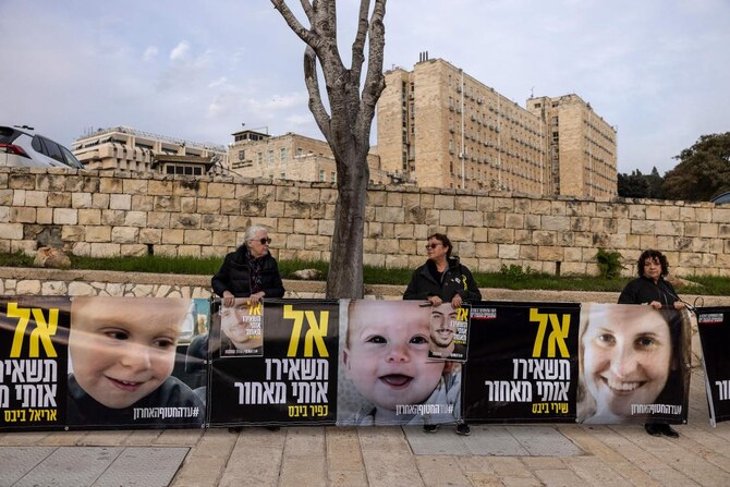Supporters of Israeli hostages held captive in the Gaza Strip since the Oct. 7, 2023 attacks hold images of the Bibas family as they protest in front of prime minister’s office in Jerusalem on February 3, 2025. (AFP)