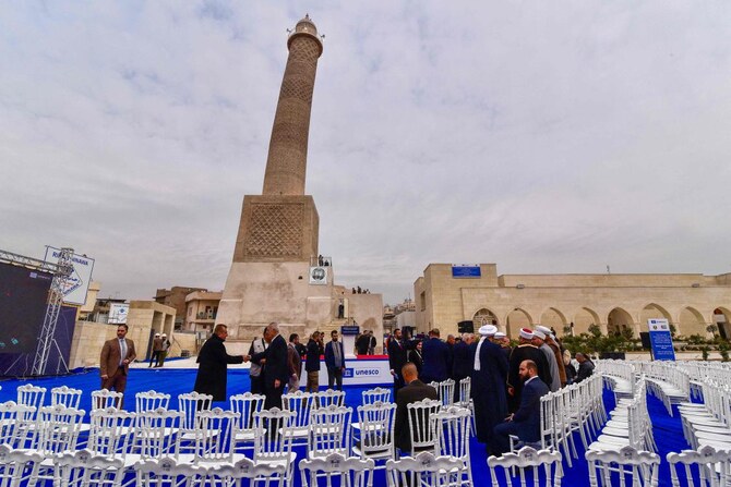Attendees arrive for a UNESCO ceremony to announce the end of restoration work on the leaning Al-Hadba minaret of the historic Great Mosque of Al-Nuri on February 5, 2025, as part of ongoing reconstruction projects of old Mosul that was damaged during the fight with the Daesh group. (AFP)