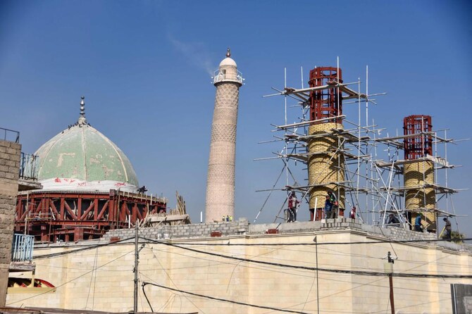 Builders work on the ongoing reconstruction of the historic Great Mosque of Al-Nuri, whose “Al-Hadba” leaning minaret (C) which dates back to the 12th century was destroyed by Daesh group fighters, in Mosul’s old city in northern Iraq on February 3, 2025. (AFP)