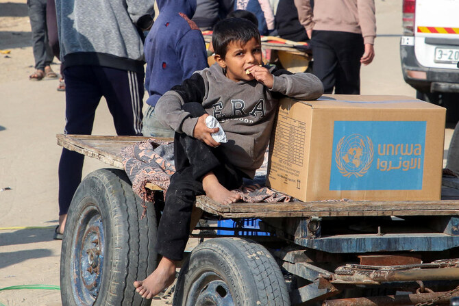 A Palestinian boy sits beside an aid box provided by UNRWA outside a distribution point in Khan Younis in the southern Gaza Strip, February 4, 2025. (Reuters)