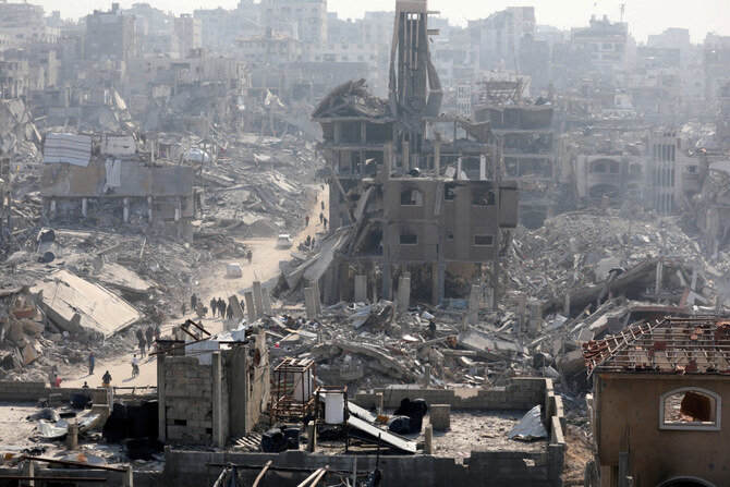 People walk past the rubble of destroyed buildings in Jabalia, northern Gaza Strip, on January 30, 2025. (REUTERS)