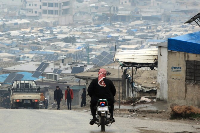 A man rides a motorcycle in the camp of Atme for displaced people, on the outskirts of Idlib in northwestern Syria, on February 5, 2025 (AFP)
