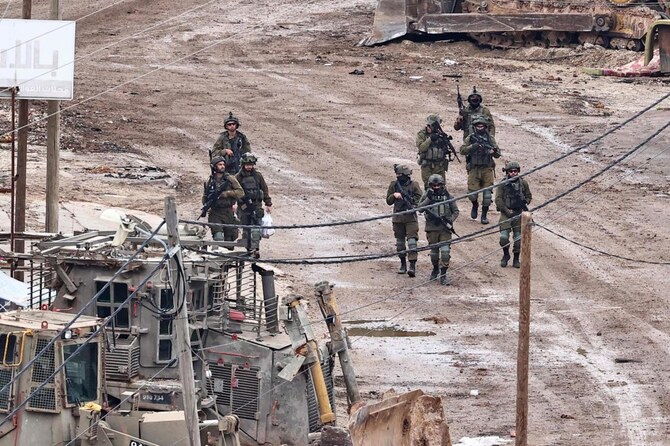 Israeli soldiers walk on a street as they conduct a raid in al-Faraa camp for Palestinian refugees near Tubas in the occupied West Bank on February 10, 2025. (Photo by Zain JAAFAR / AFP)