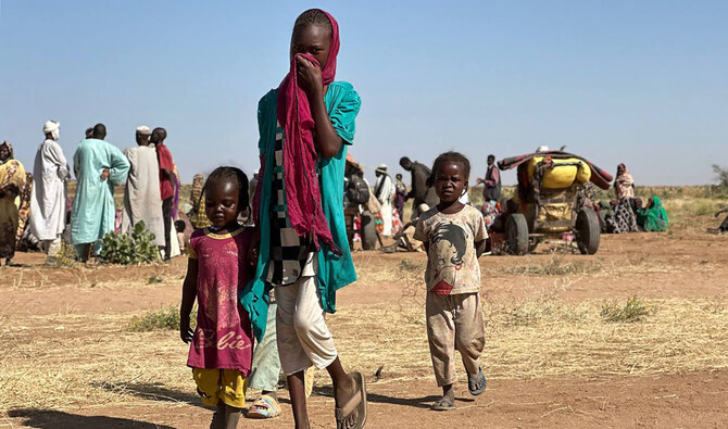 A displaced Sudanese woman, accompanied by children, walks at a camp near the town of Tawila in North Darfur on February 11, 2025. (AFP/File)